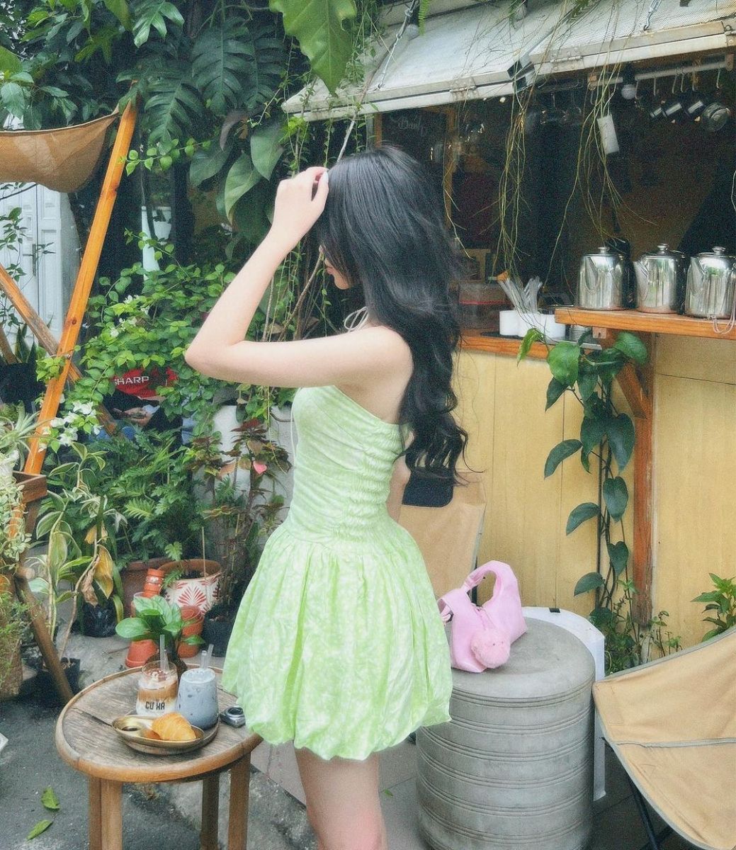 Cô gái xinh đẹp trong bộ đầm xanh giữa quán cà phê