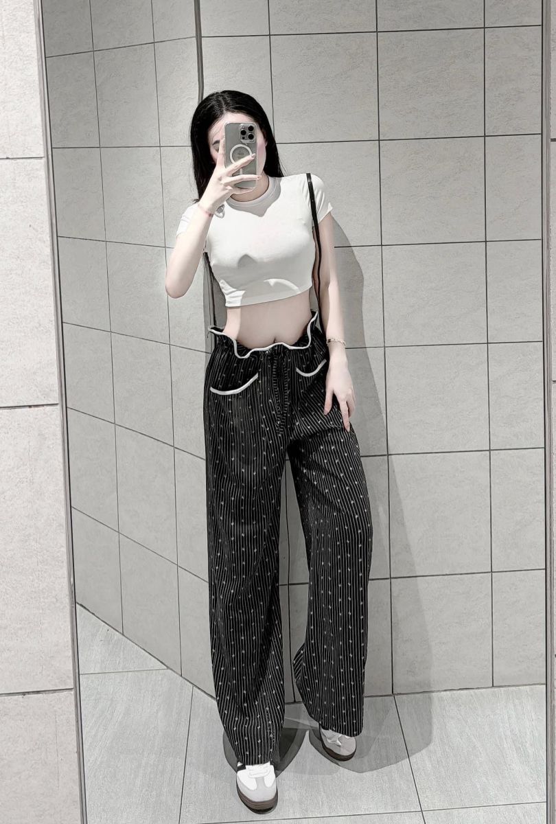 Cô gái xinh đẹp trong bộ trang phục crop top trắng và quần sọc