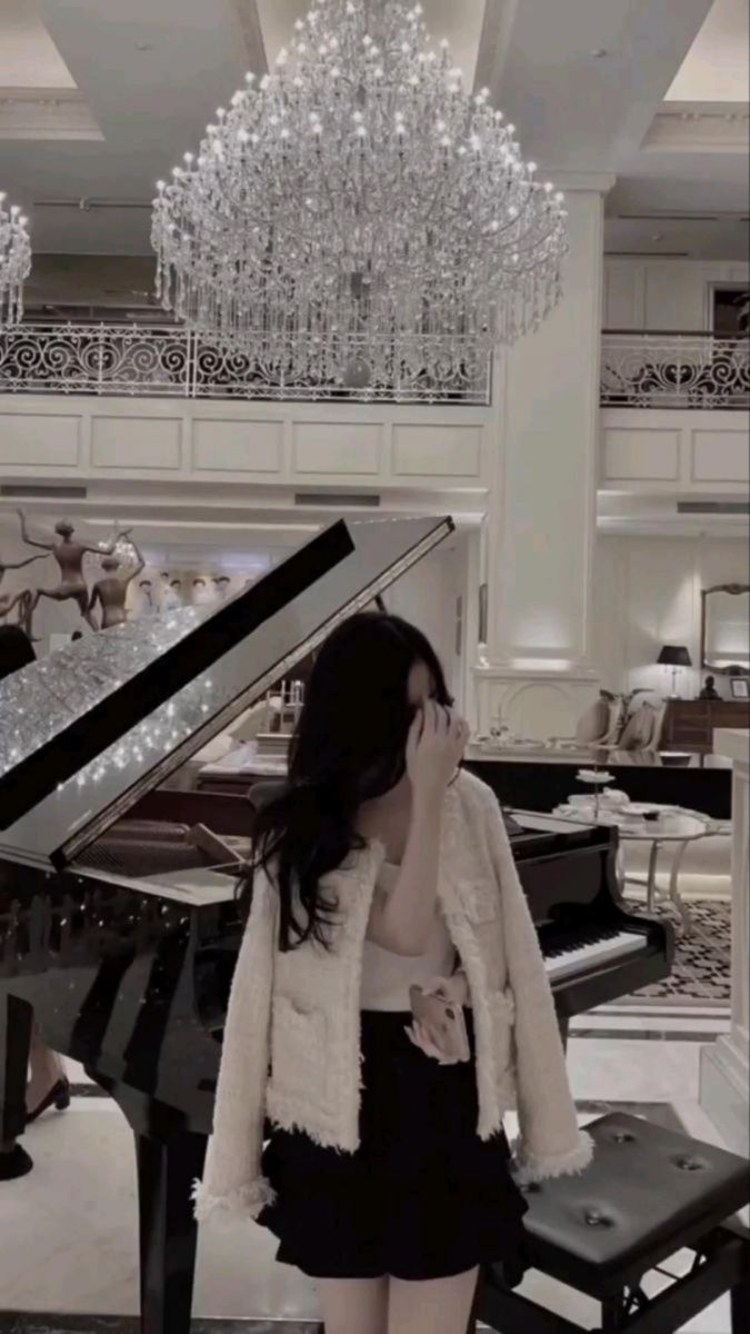Cô gái xinh đẹp trong bộ trang phục nổi bật bên cây đàn piano