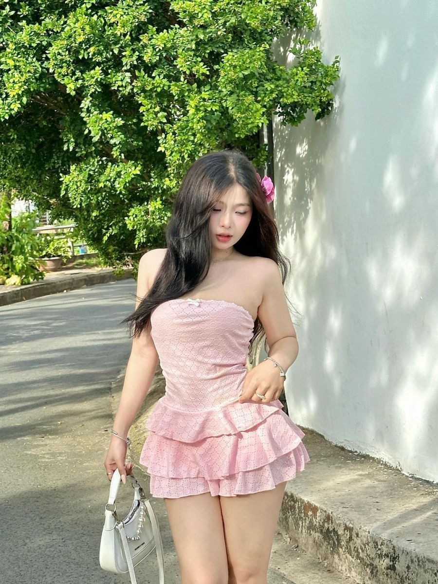 Cô gái xinh đẹp trong bộ váy hồng trên con đường vàng