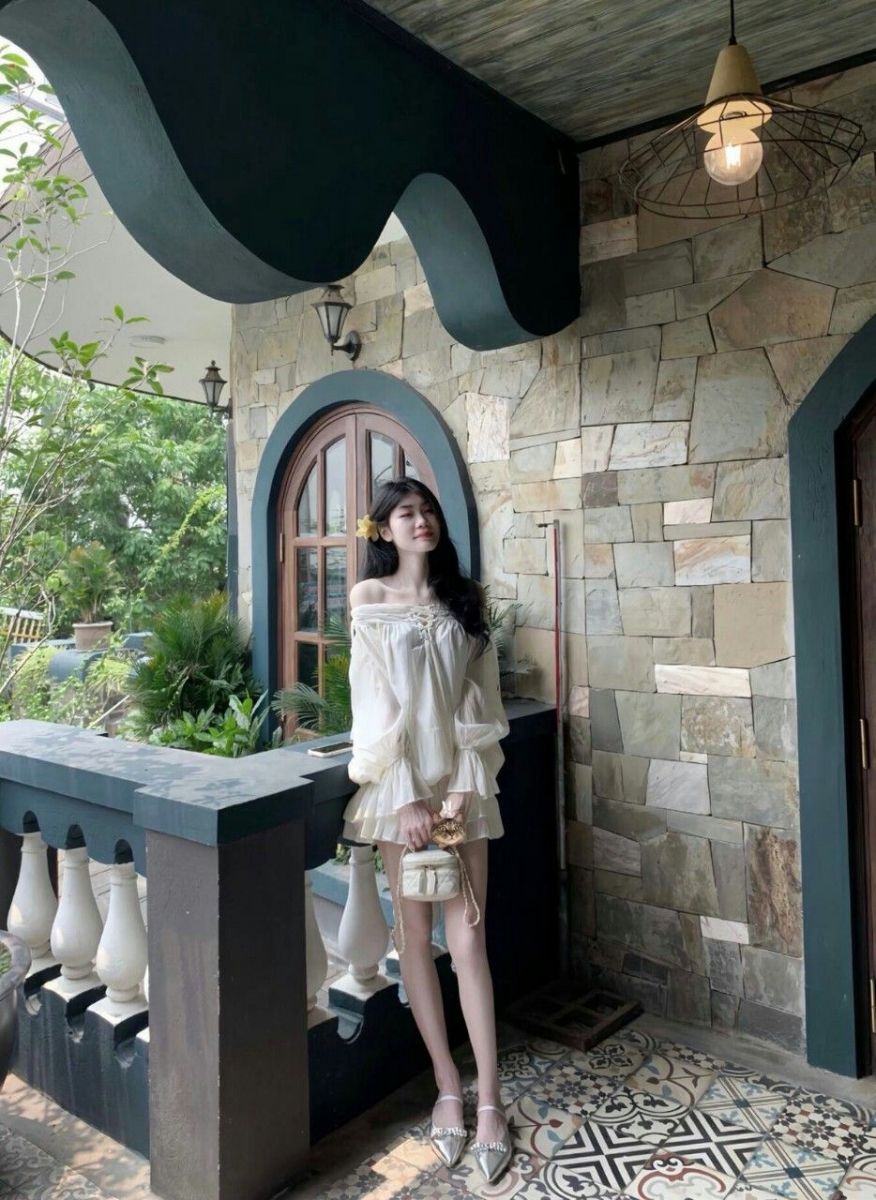 Cô gái xinh đẹp trong bộ váy trắng trên ban công