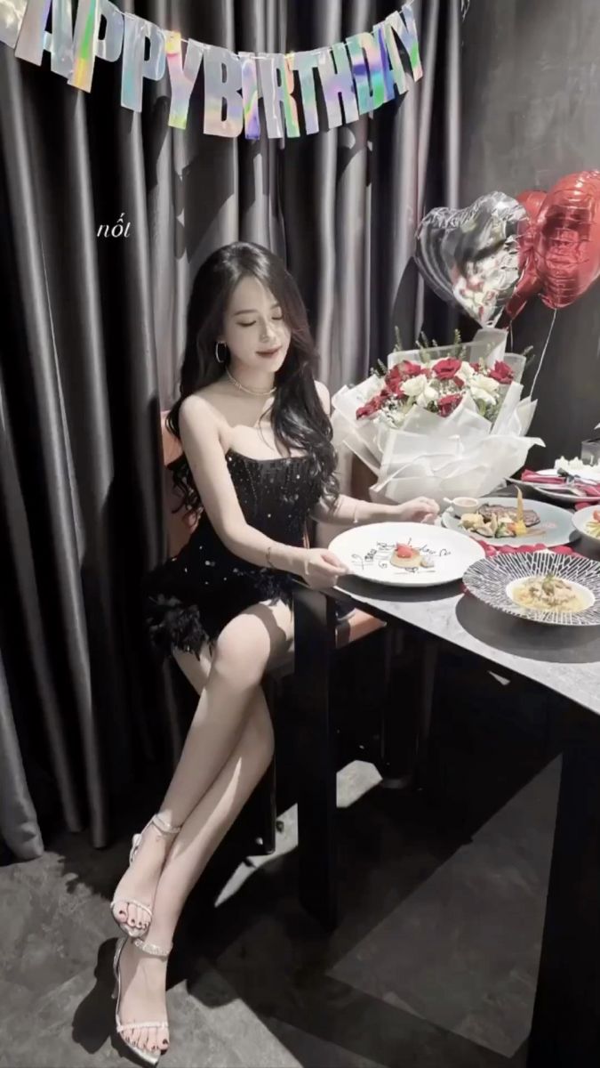 Cô gái xinh đẹp trong đầm đen sequin bên bàn tiệc sinh nhật