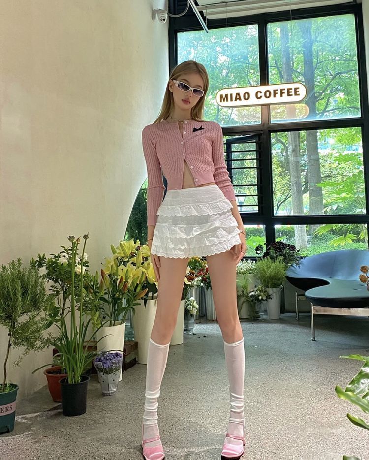 Cô gái xinh đẹp trong quán cà phê với áo cardigan hồng