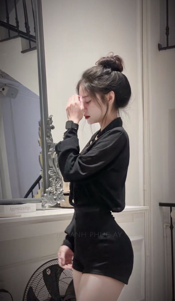 Cô gái xinh đẹp trong trang phục áo sơ mi đen và quần short ngắn