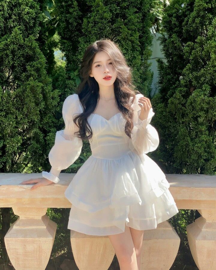 Cô gái xinh đẹp trong trang phục trắng duyên dáng bên lan can