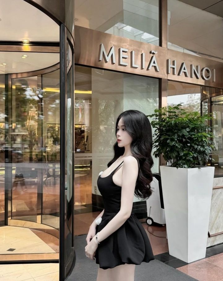 Cô gái xinh đẹp trong váy đen bên cửa sổ khách sạn sang trọng