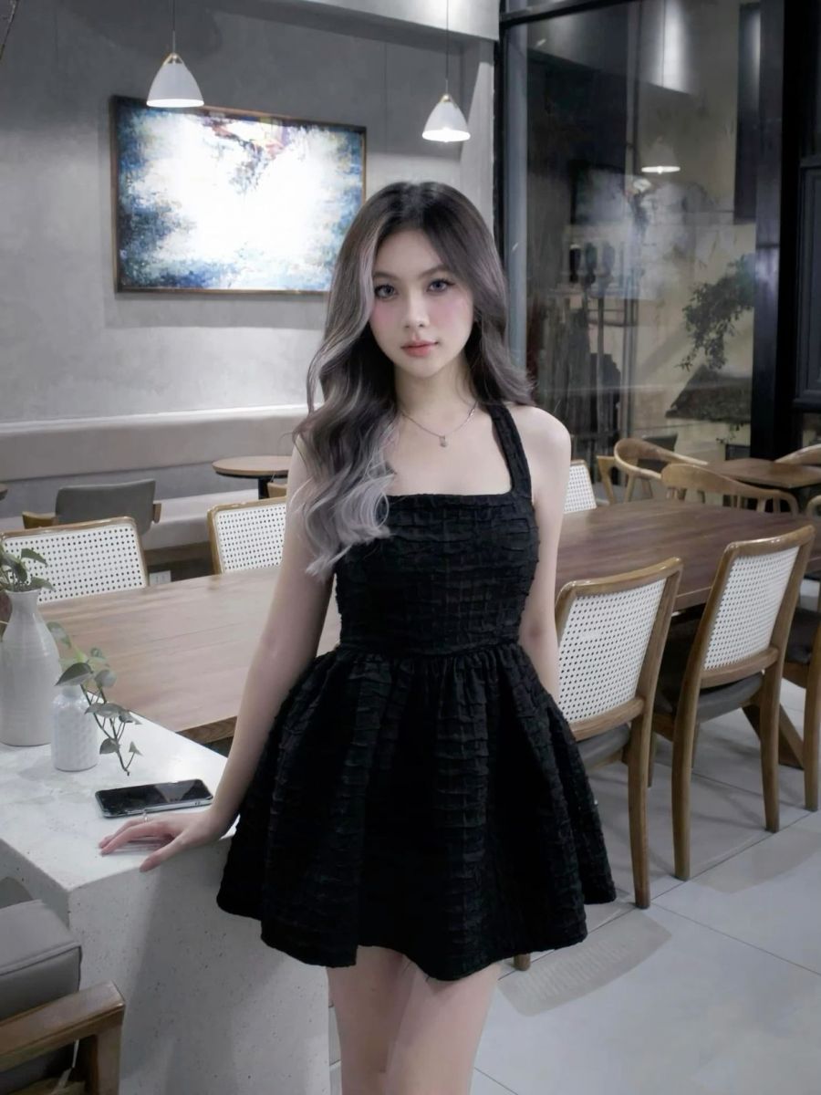 Cô gái xinh đẹp trong váy đen tại quán cà phê hiện đại