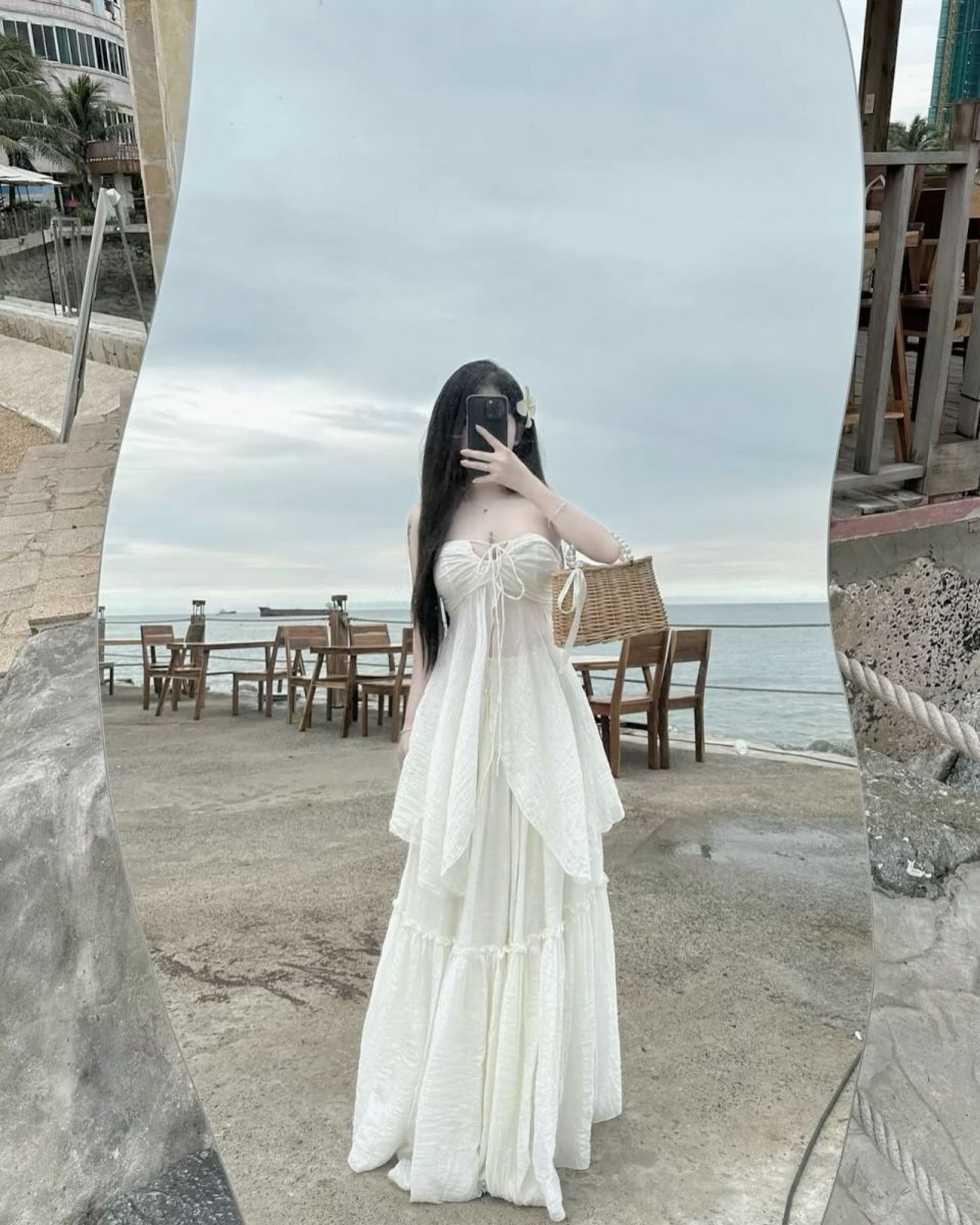 Cô gái xinh đẹp trong váy trắng bên bờ biển