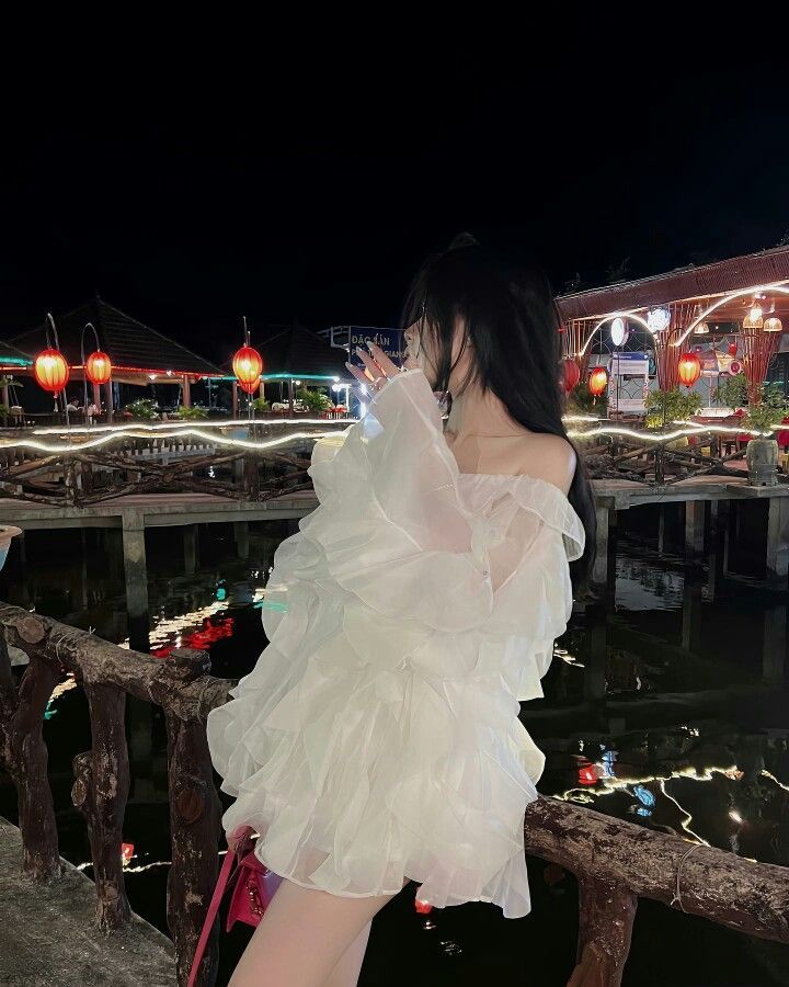 Cô gái xinh đẹp trong váy trắng bên hồ nước