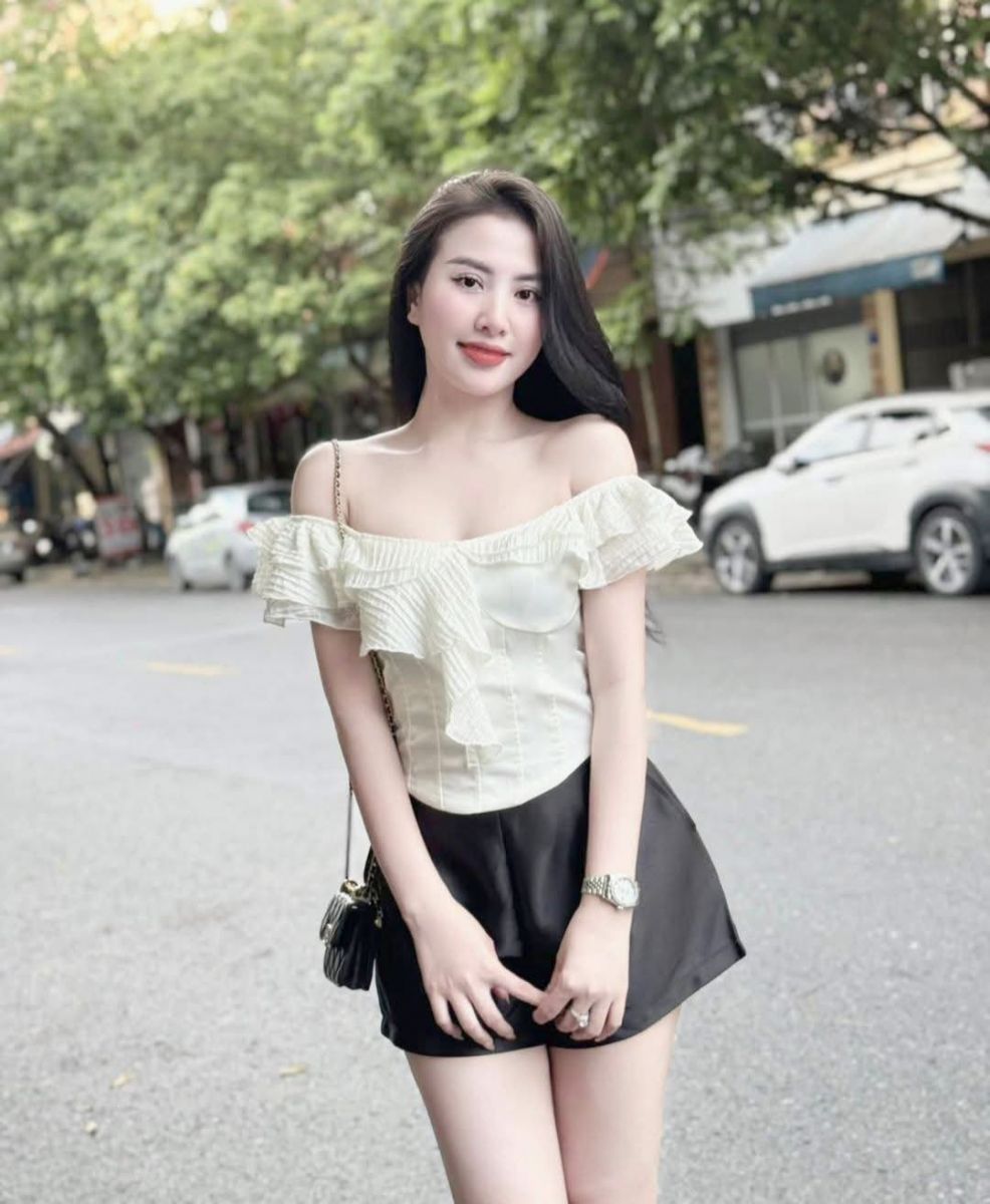 Cô gái xinh đẹp trong váy trắng lệch vai trên phố Tây