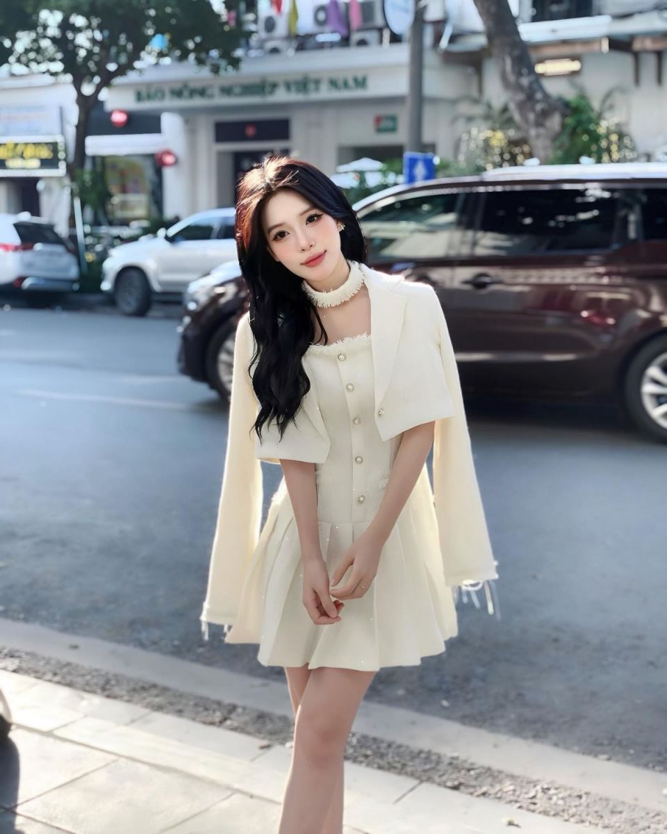 Cô gái xinh đẹp trong váy trắng trên phố