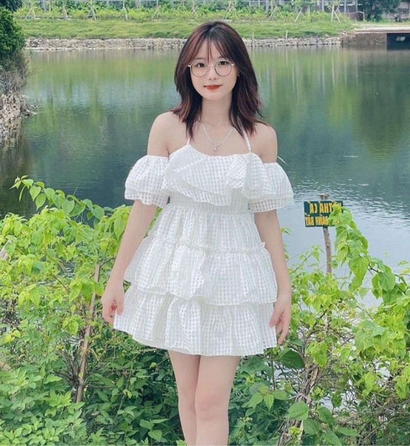Cô gái xinh đẹp trong váy trắng xòe hoa tiết ke