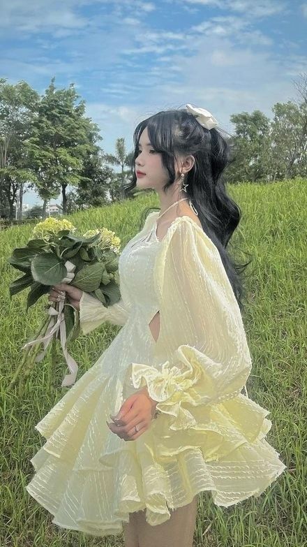 Cô gái xinh đẹp trong váy vàng giữa cánh đồng xanh