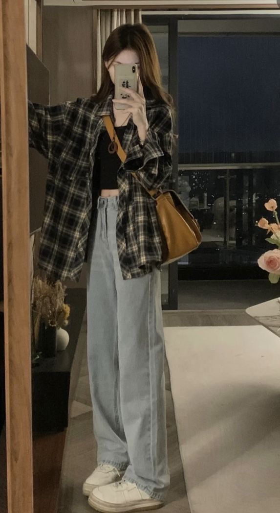 Cô gái xinh đẹp với áo sơ mi cổ điển và quần jeans rộng
