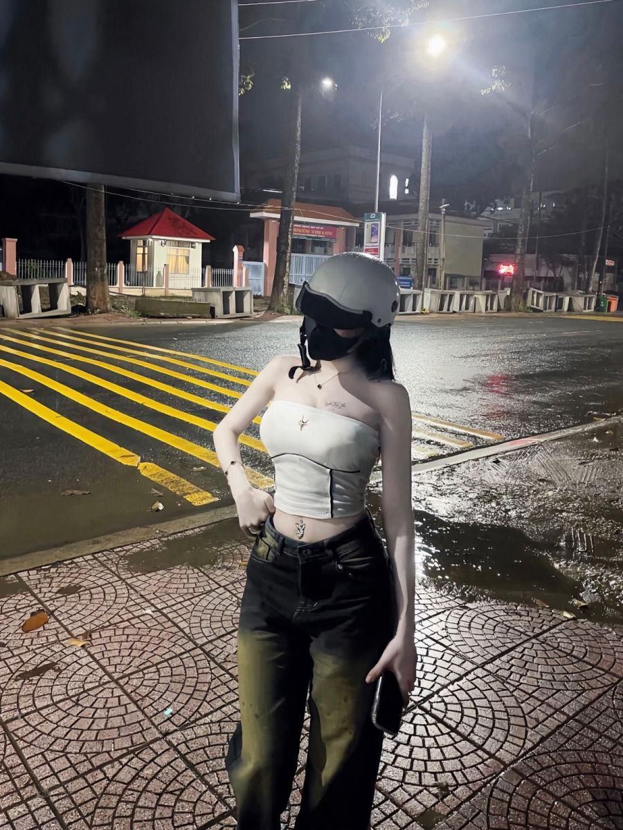 Cô gái xinh mặc áo crop top trắng và quần jeans đen trên phố
