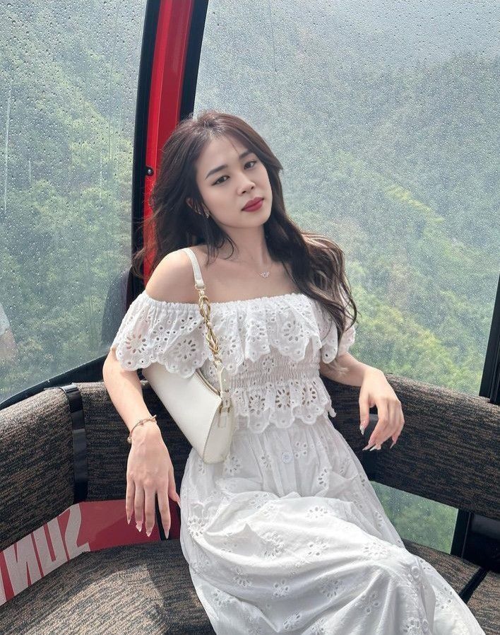 Cô gái xinh mặc áo dài trắng trong cabin cáp treo