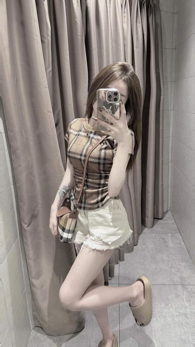 Cô gái xinh mặc áo thun kẻ sọc và quần short trắng thời thượng