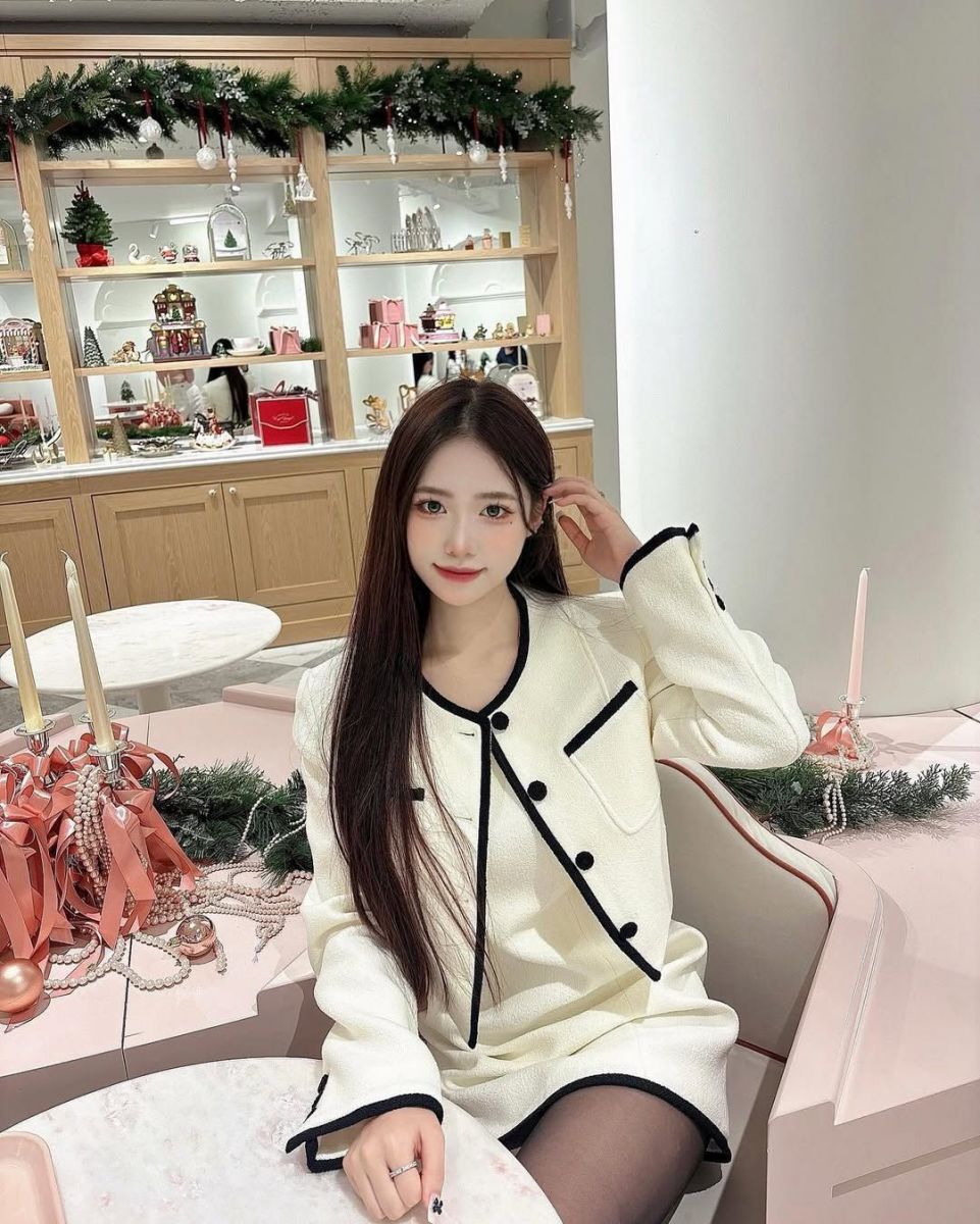 Cô gái xinh mặc đồ trắng ngồi trong quán cà phê sang trọng