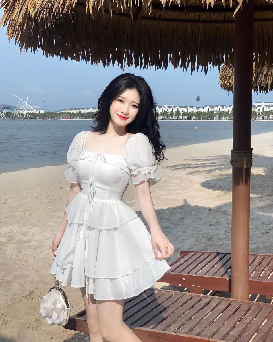 Cô gái xinh mặc váy trắng bên bờ biển