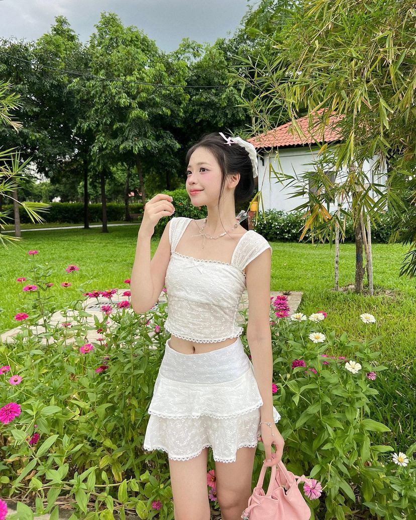 Cô gái xinh mặc váy trắng giữa khu vườn hoa rực rỡ