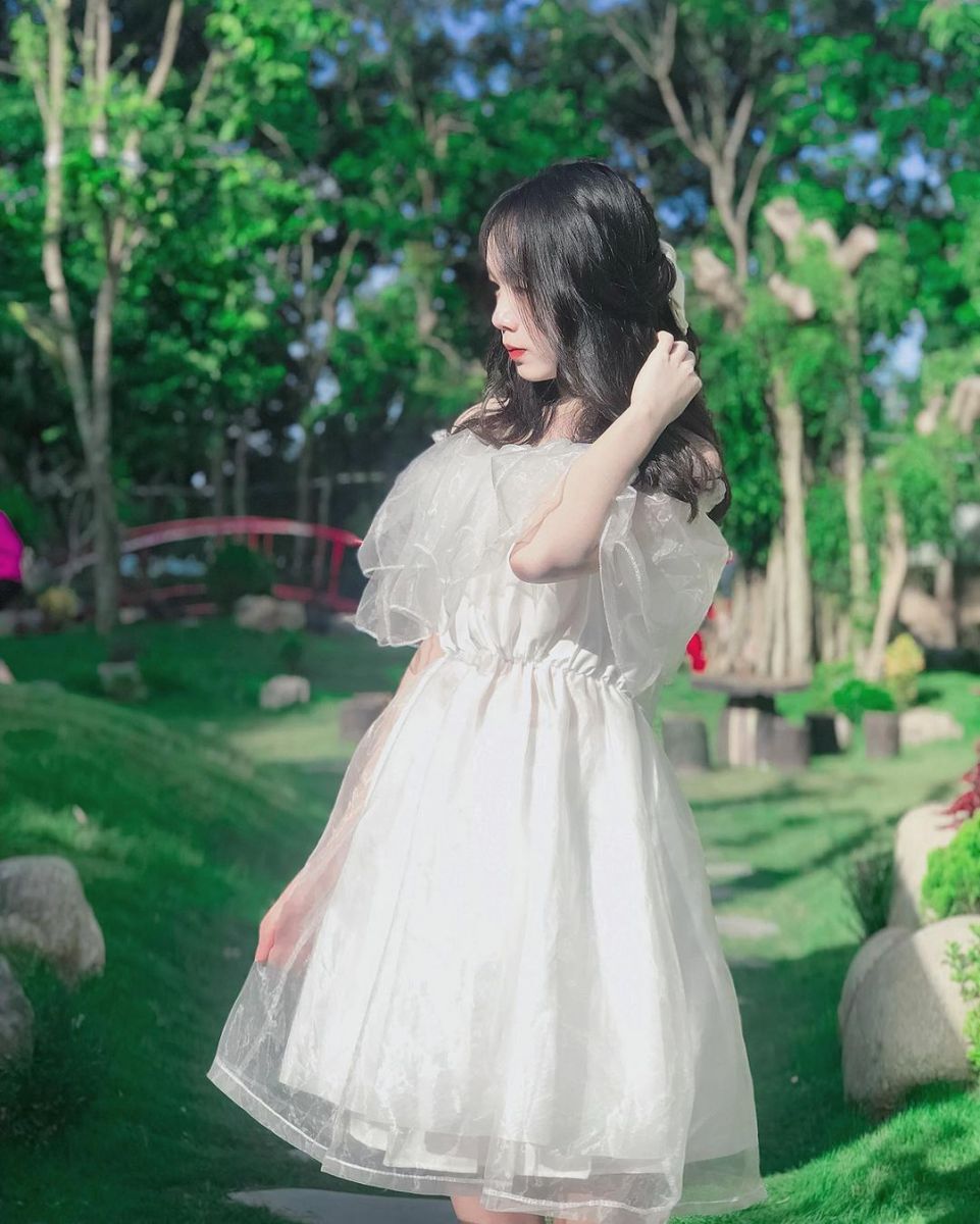 Cô gái xinh mặc váy trắng giữa khu vườn xanh tươi