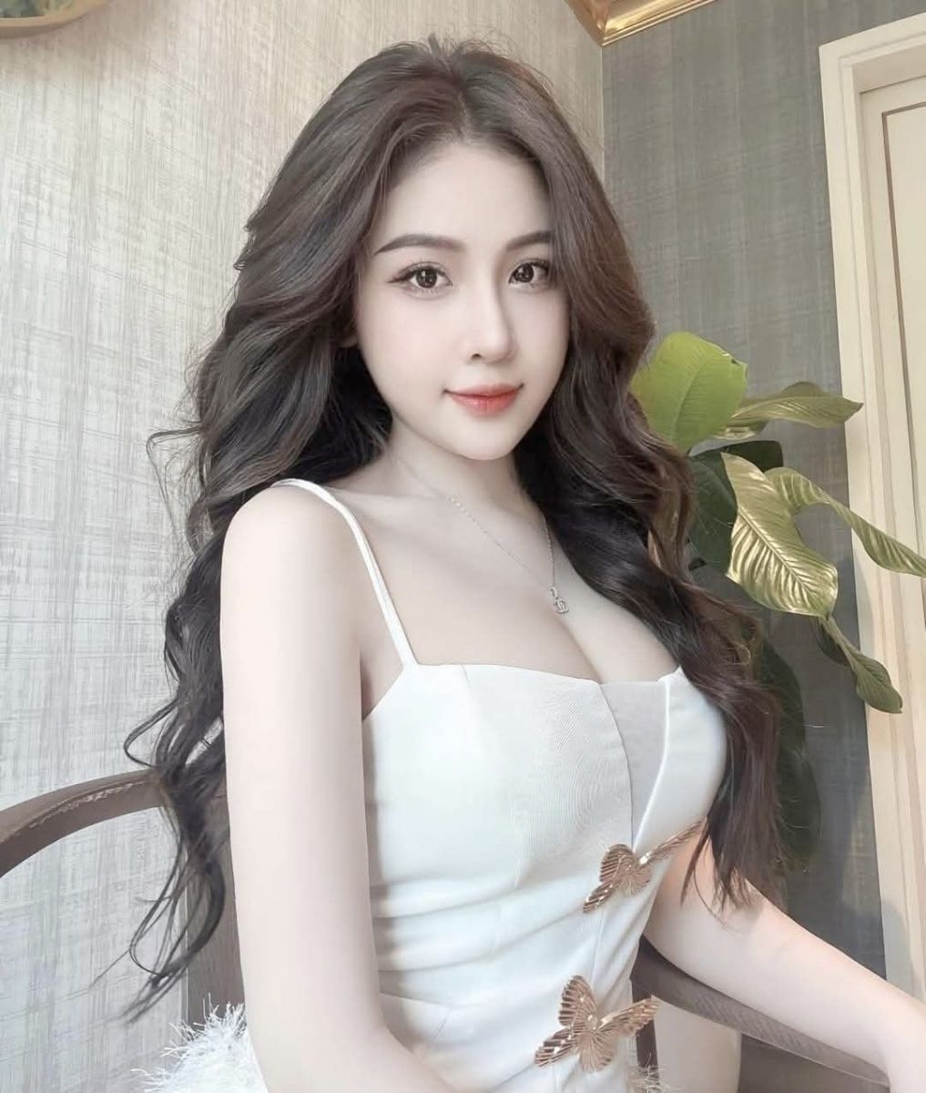 Cô gái xinh mặc váy trắng tự tin trong không gian hiện đại