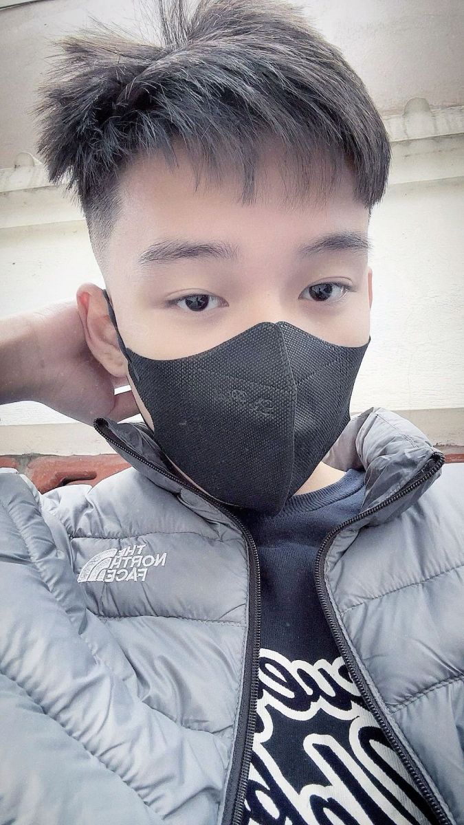 Đàn ông mặc áo khoác phao màu xám và áo phông đen chụp selfie