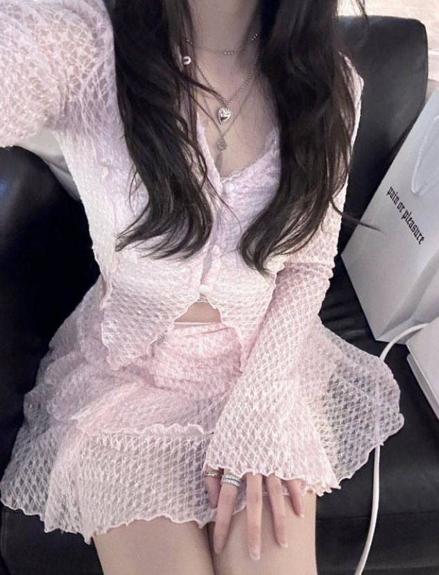 Gái cute tóc dài trong trang phục màu hồng pastel ngồi trên ghế sofa