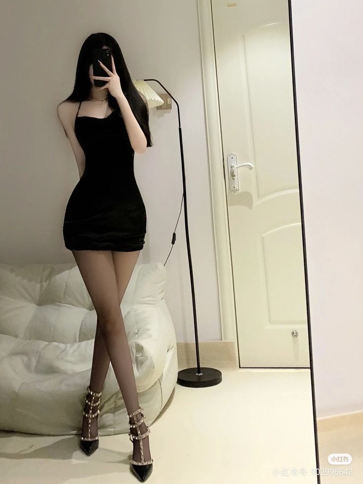 Gái đẹp diện váy đen ôm sát, tạo dáng trước gương