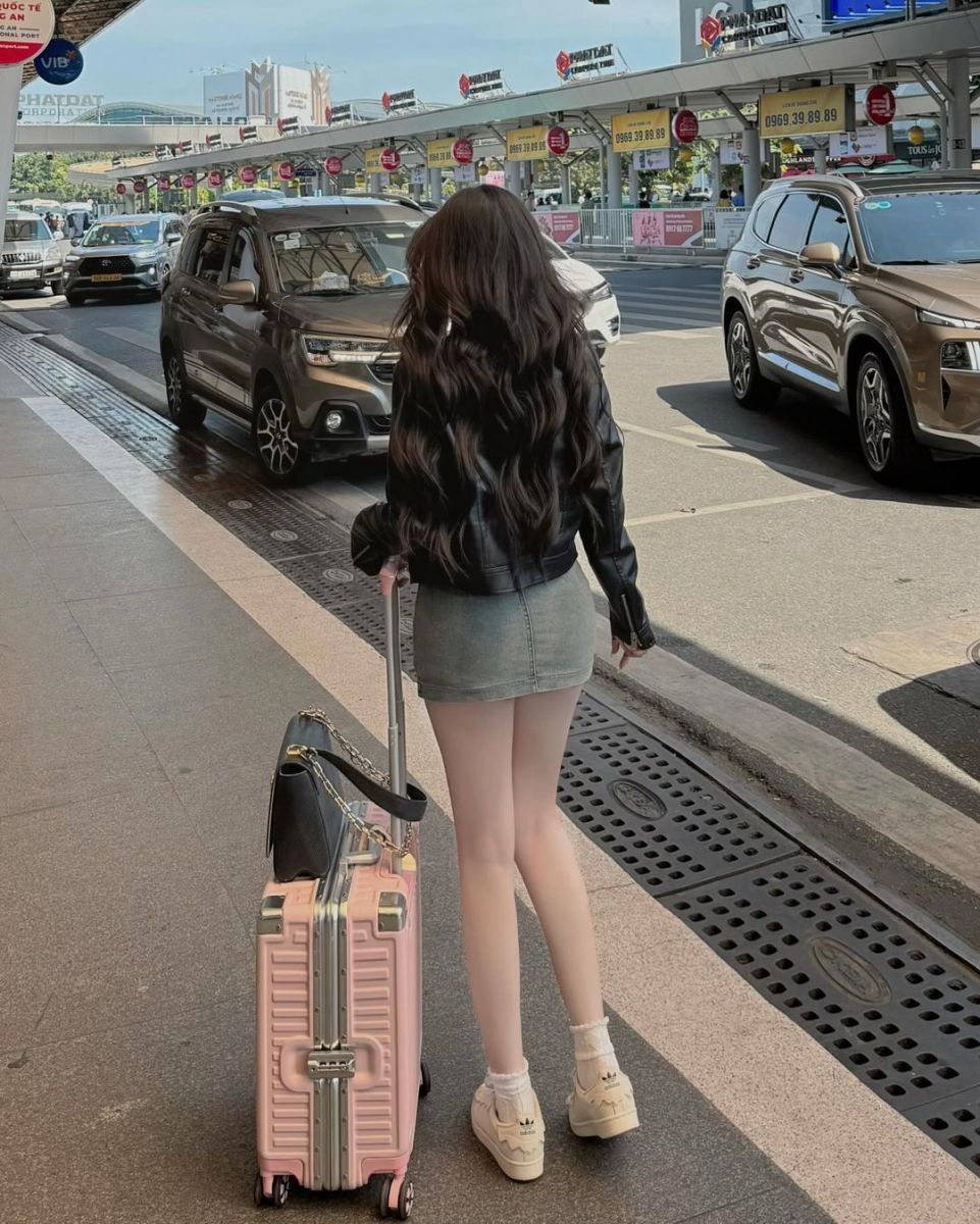 Gái đẹp mặc áo khoác da đen và chân váy denim ngắn