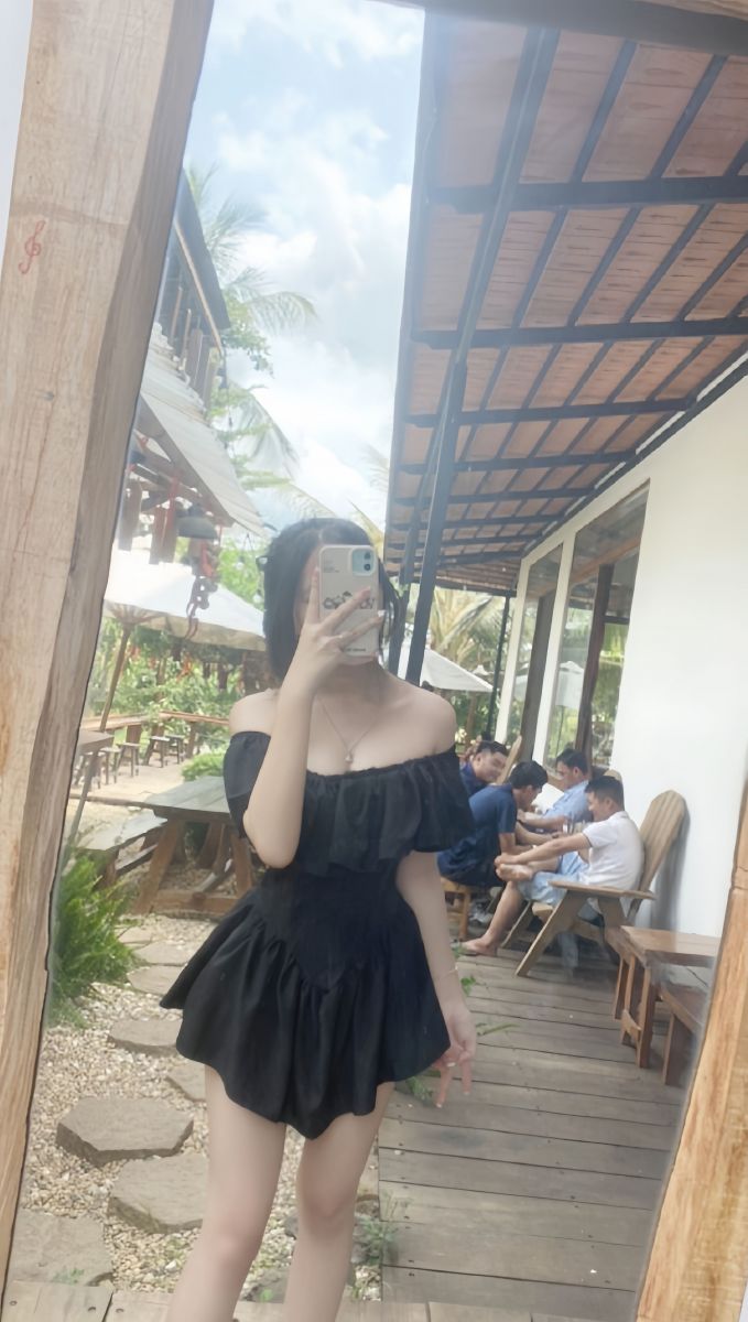Gái đẹp mặc váy đen chụp hình selfie tại quán cafe ngoài trời