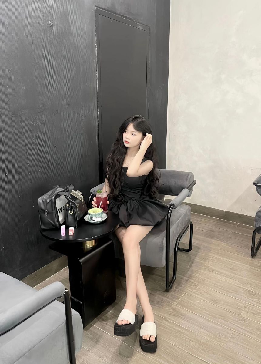 Gái đẹp mặc váy đen ngồi thưởng thức nước trái cây