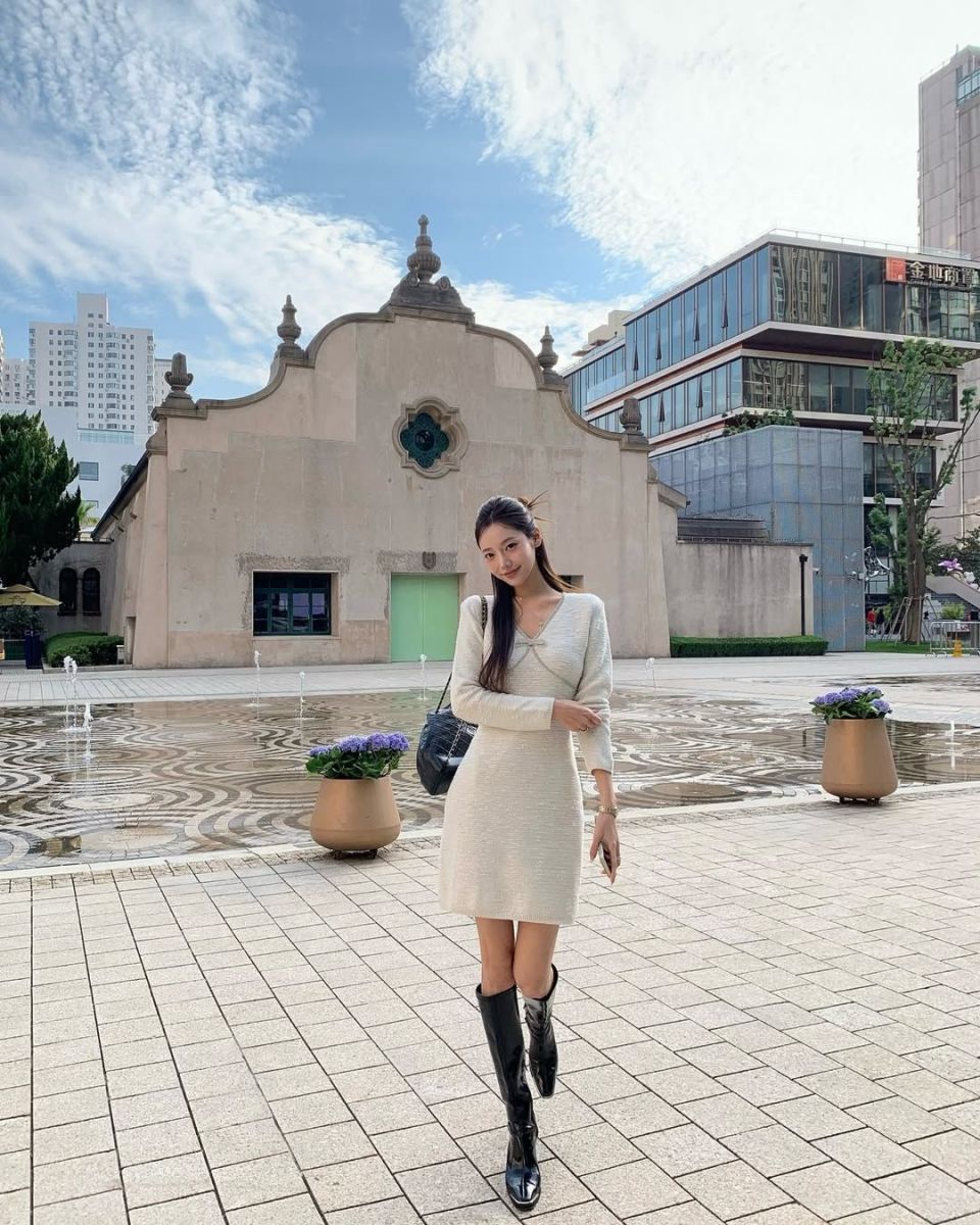 Gái đẹp mặc váy sáng kết hợp boots đen trong không gian hiện đại