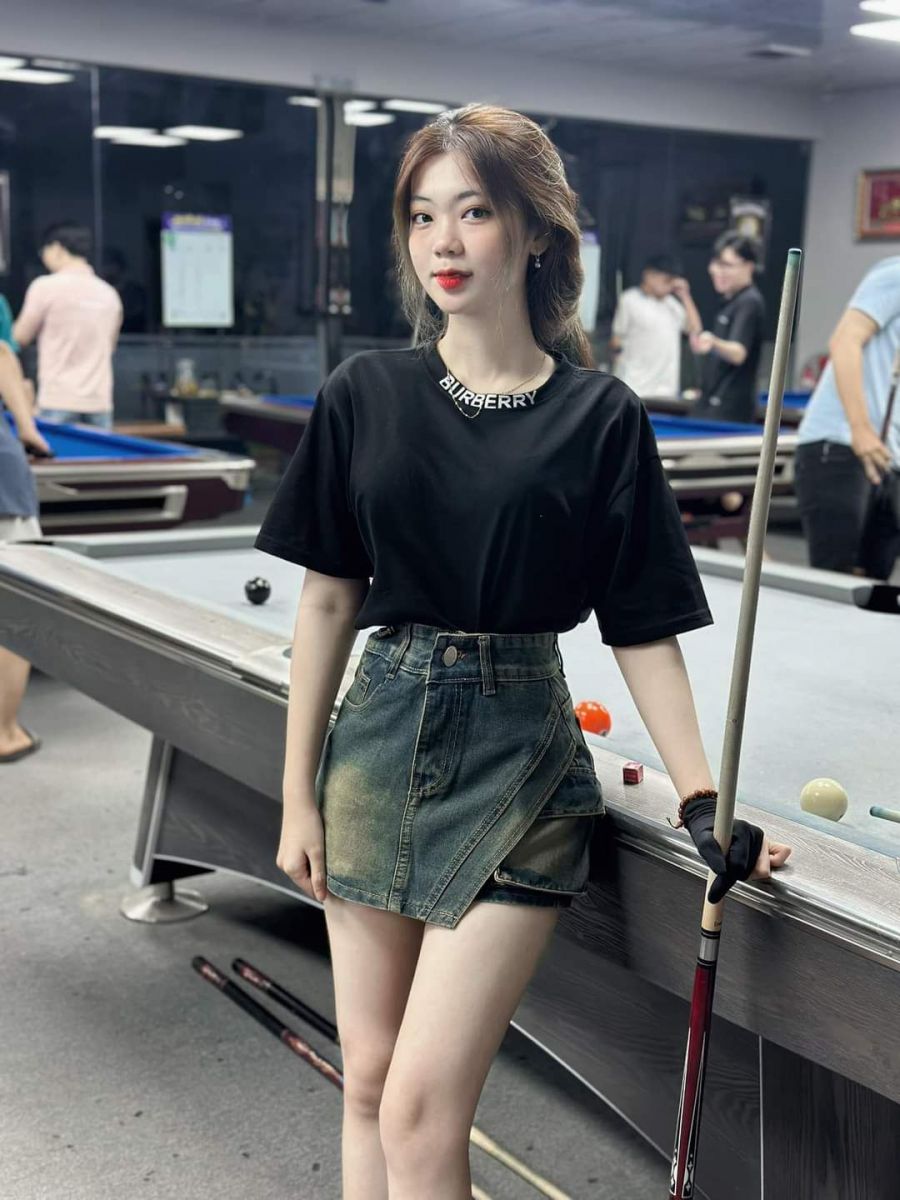 Gái đẹp mặc váy và áo phông đen nổi bật bên bàn bi-a