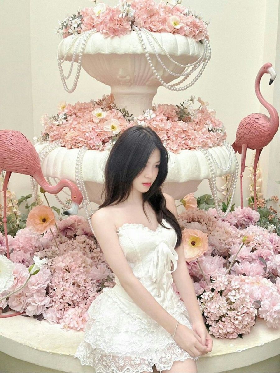 Gái đẹp trong váy trắng bên đài phun nước hoa hồng