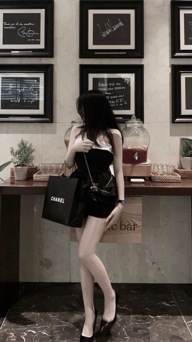 Gái mặc váy ngắn bên túi xách Chanel ở quầy bar sang trọng