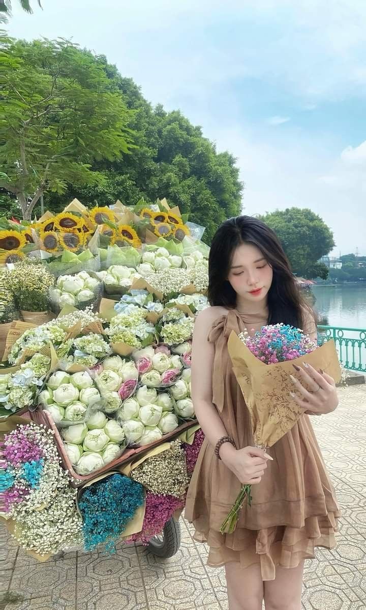 Gái mặc váy ngắn màu nâu bên xe hoa đầy sắc màu