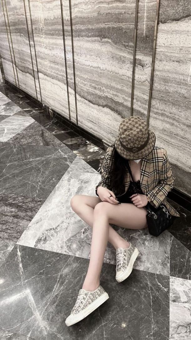 Gái trẻ khoác áo kẻ cá tính và quần short đen bên hoa