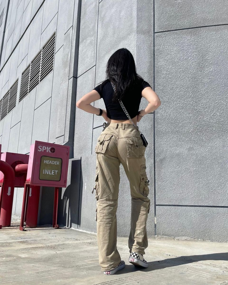 Gái trẻ mặc áo crop top đen với quần cargo màu be