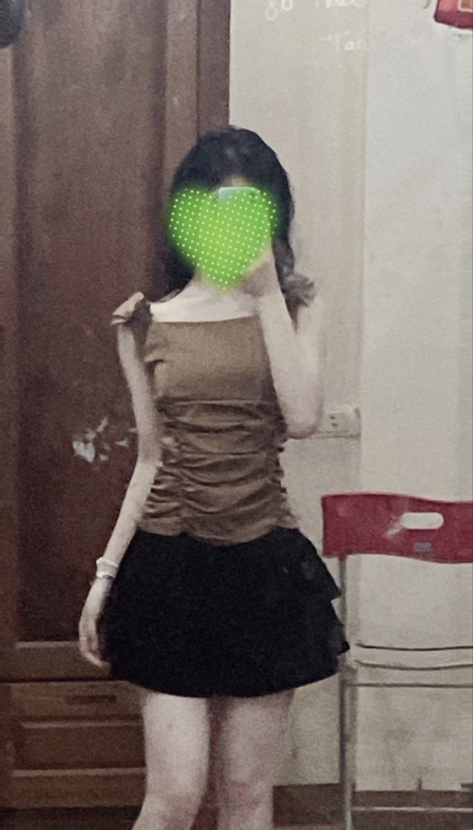 Gái trẻ mặc áo croptop nâu và chân váy đen chụp ảnh trong gương