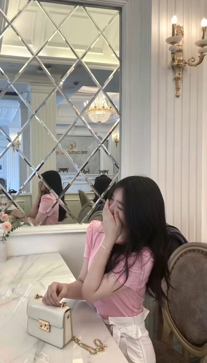 Gái trẻ mặc áo phông hồng ngồi ở quán cà phê
