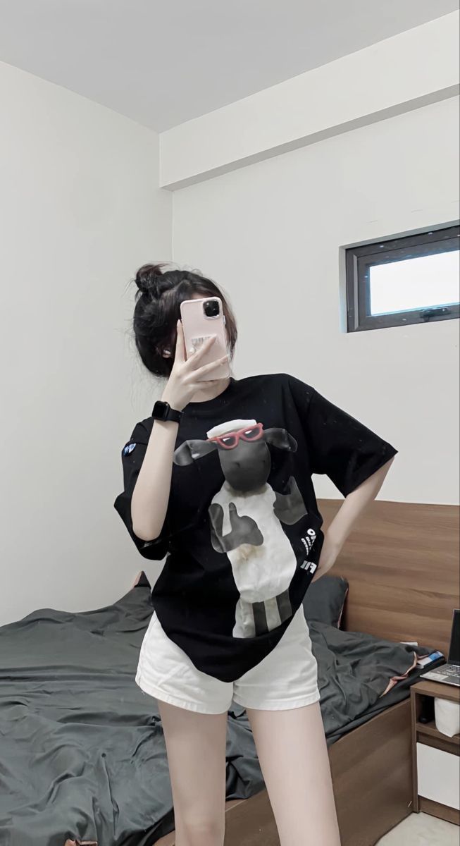 Gái trẻ mặc áo thun đen và quần shorts trắng chụp ảnh selfie