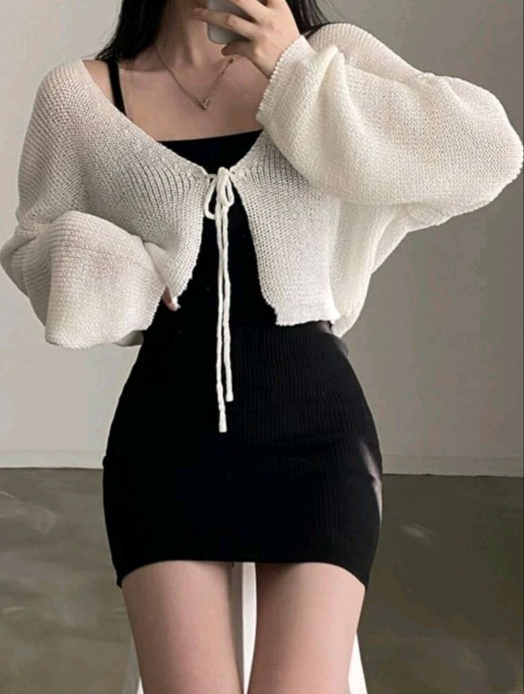 Gái trẻ mặc cardigan trắng và váy đen chụp ảnh selfie