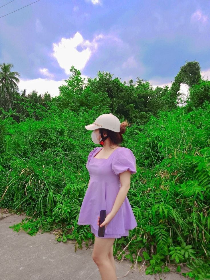 Gái trẻ mặc váy tím giữa khu vườn cây xanh tươi