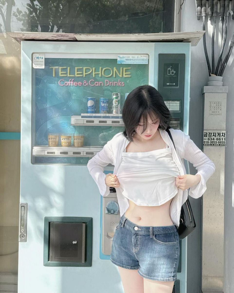 Gái trẻ xinh đẹp bên máy bán hàng tự động