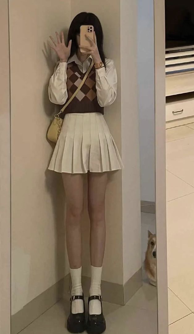 Gái trẻ xinh đẹp trong áo sơ mi trắng và áo gilet nâu