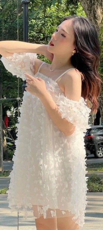 Gái trẻ xinh đẹp trong chiếc đầm trắng bên cây xanh