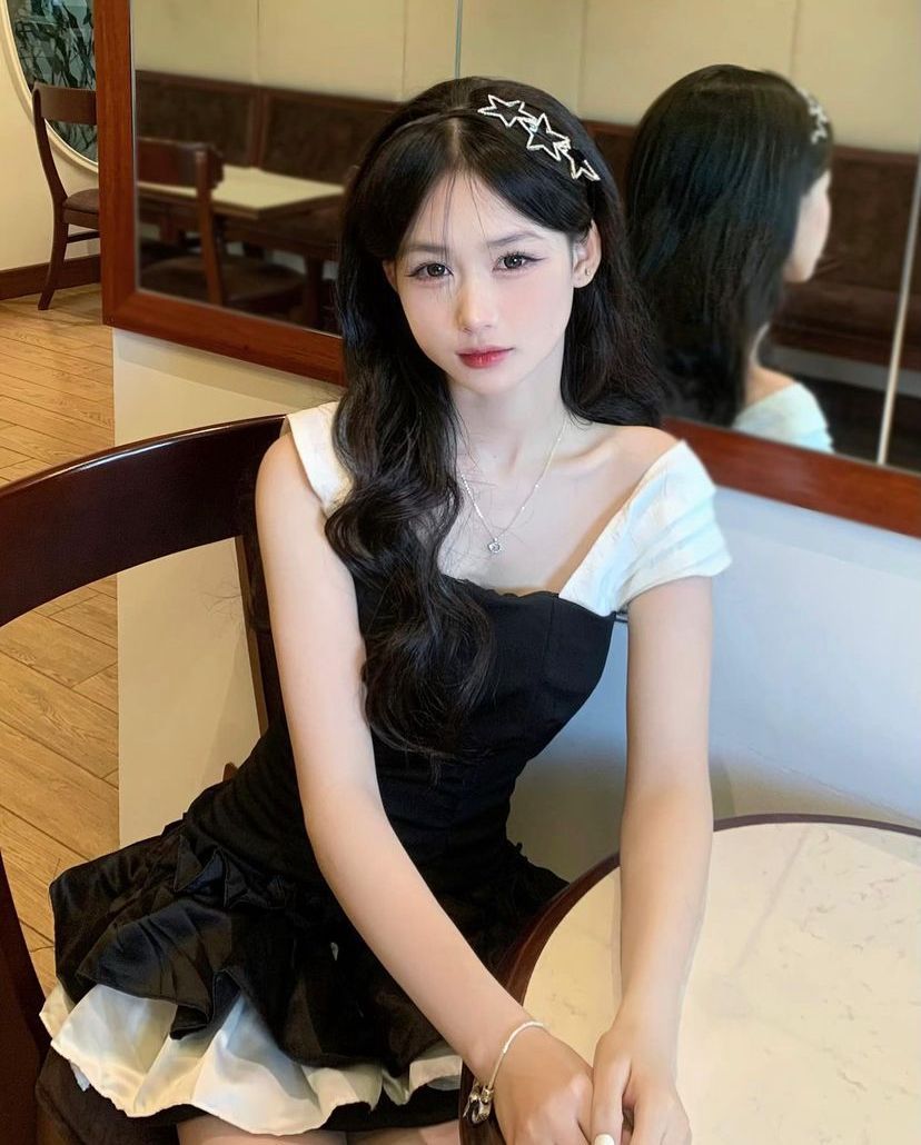 Gái trẻ xinh đẹp trong váy đen tại quán cà phê