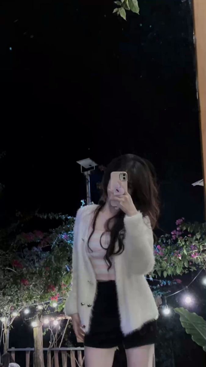 Gái xinh cởi áo phông sọc và áo khoác trắng chụp ảnh selfie tại vườn cây