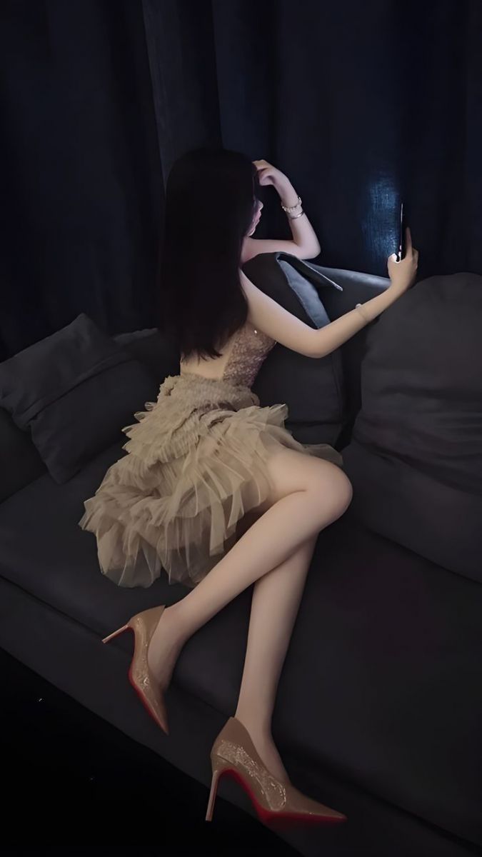 Gái xinh diện đầm ngủ màu nude trên sofa cùng smartphone